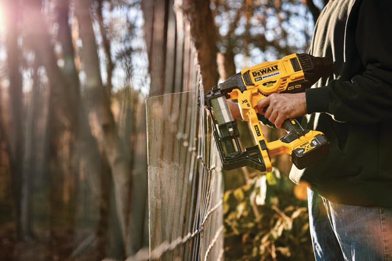 CORDLESS FENCING STAPLER being used on a wooden post by a person