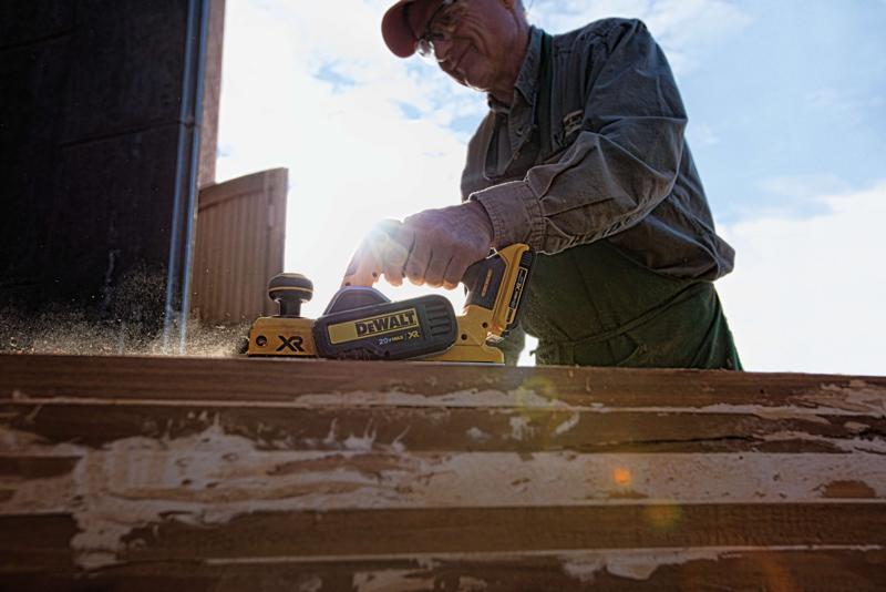   Brushless cordless planer being used by a person to ensure parallelism of cut.
