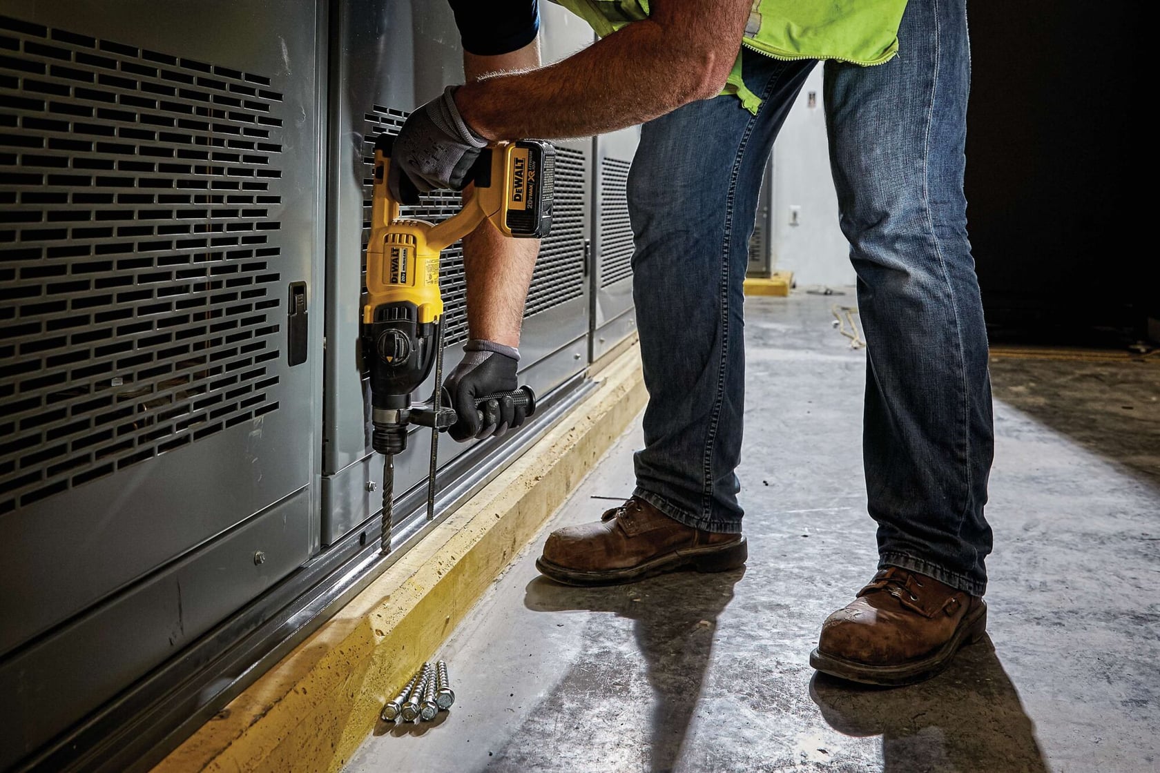 Brushless, cordless SDS PLUS D-Handle rotary hammer being used by a person